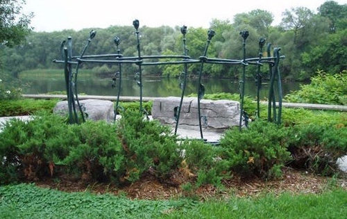 Photo of the Millennium Reflection Garden, located at the confluence of the Speed and Eramosa Rivers. The garden houses two screens made up of 7 roses each, representing the fourteen women that lost their lives at Ecole Polytechnique in December 1989. The CFUW encourages visitors to the use the space to reflect.